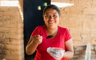 Guatemalan woman holding spoonful of ground coffee